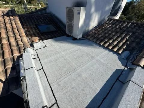Toiture-terrasse rénovée en étanchéité monocouche claire (cool roof), climatiseur et tuiles autour