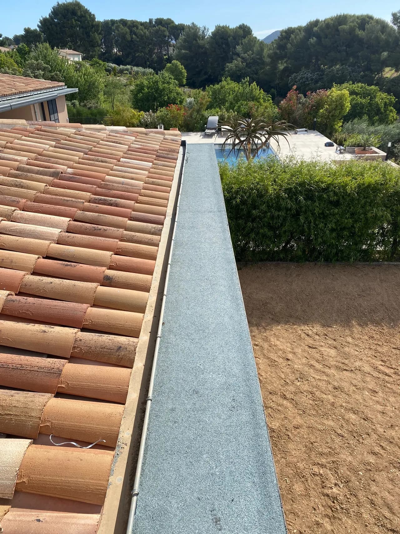 Casquette béton après réfection d'étanchéité, membrane grise le long des tuiles d'une villa en PACA