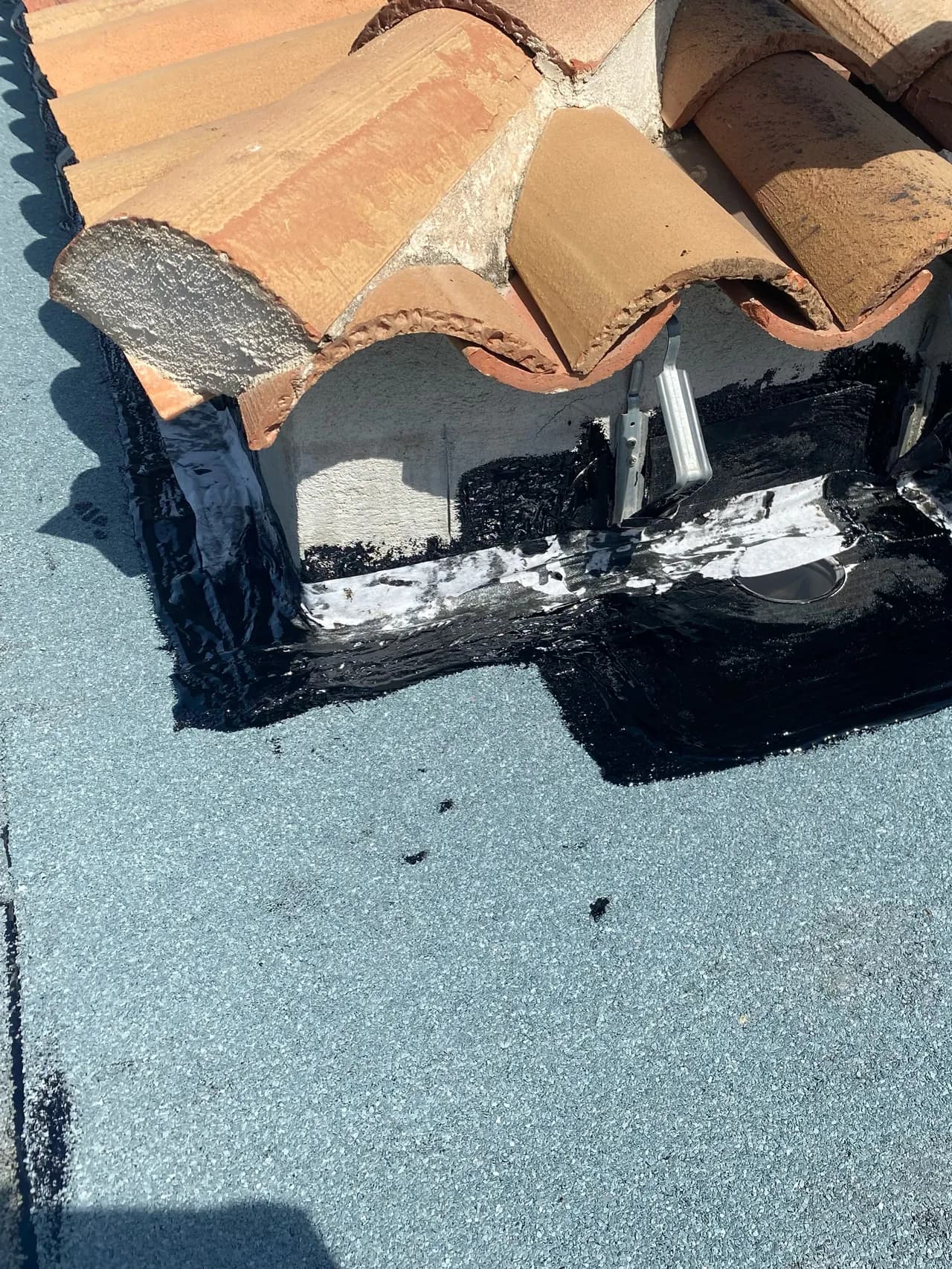 Traitement au bitume d'un relevé et d'une évacuation d'eaux pluviales, casquette béton en cours de réfection